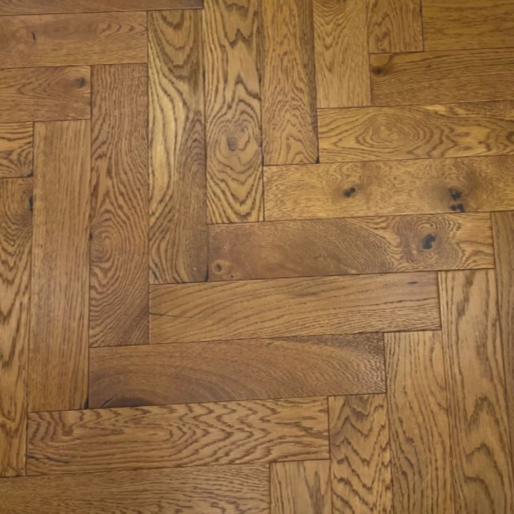 Golden oak herringbone parquet close-up